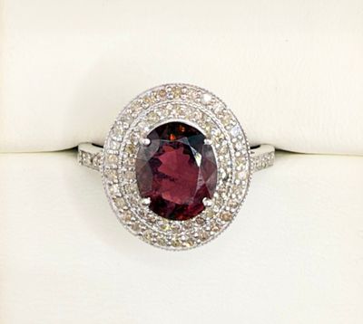 an image of a ring with a garnetite surrounded by diamonds
