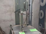 une machine posée sur une palette à côté d'un tas de bois