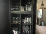 une bibliothèque noire remplie de verres dans une cuisine