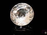 une image représentant une boule de cristal transparente posée sur une surface noire