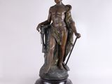 statue en bronze représentant une femme tenant un bâton et un sac
