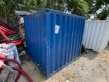 un bac bleu posé par terre à côté d'un tas de tuyaux