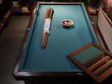 a pool table with a bowl of fruit and two chopsticks on it