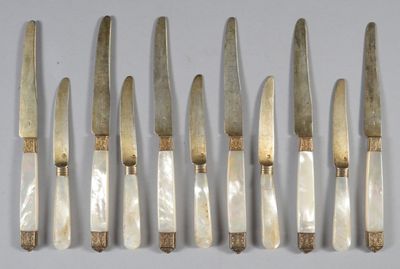 six knives are lined up in a row on a white surface