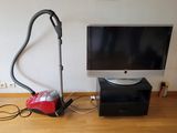 une photo représentant un téléviseur et un aspirateur posés sur un parquet