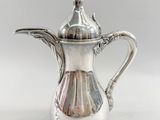 an image of a silver coffee pot sitting on top of a white table