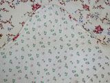 a white blanket with red and blue flowers on it