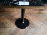 une petite table sur laquelle figure un chiffre, posée sur un plancher en bois