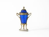 un vase bleu orné d'un motif doré sur le dessus