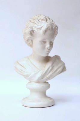 white marble bust of a young boy with curly hair on a pedestal