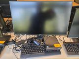 trois écrans et un clavier posés sur un bureau