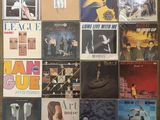 many different album covers on the wall of a room