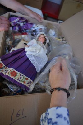 someone is putting a doll in a box with other dolls in it
