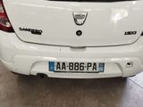 the back end of a white car parked in a garage