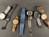five different types of watches laid out on a table