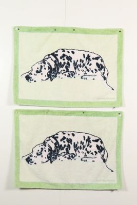 Deux dalmatiens noirs et blancs sont accrochés au mur.