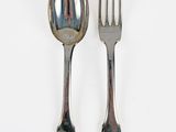 two spoons and a fork on a white surface