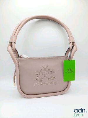 un gros plan sur un sac à main rose orné d'une étiquette verte