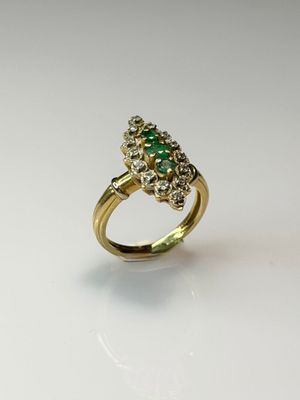 a close up of a gold ring with a green stone