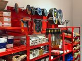 une étagère rouge sur laquelle sont disposés de nombreux outils de toutes sortes