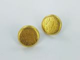 a pair of gold tone metal buttons on a white surface