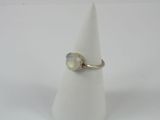 un gros plan d'une bague sertie d'une pierre blanche