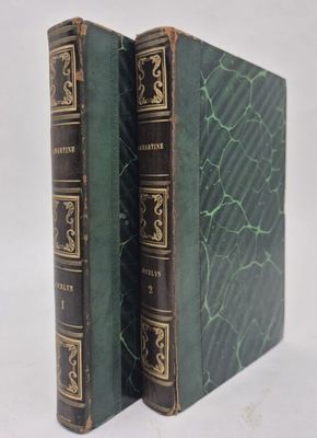 two green books sitting on top of each other on a white surface