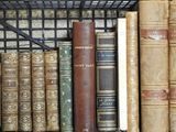 many old books on a shelf in a book case