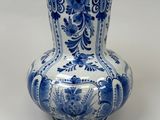 a blue and white vase sitting on a white surface