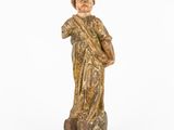 an old wooden statue of a man holding a cross