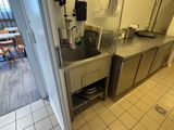 une cuisine équipée d'un évier et d'une télévision fixée au mur