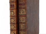 two old books sitting on top of each other on a table