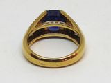 Gros plan sur une bague en or ornée d'une pierre bleue