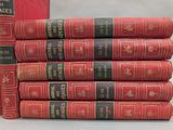 several red books stacked on top of each other on a table