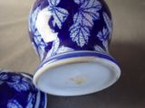a blue and white vase with a lid on a table