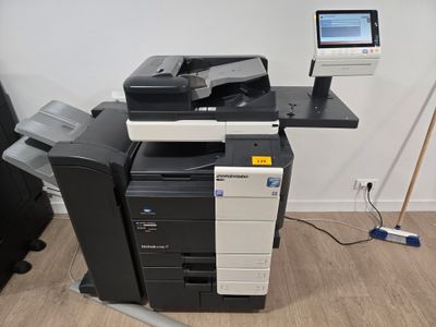 une imprimante posée sur un bureau, à côté d'une chaise