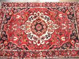 a red rug with a medallion design on the middle of it