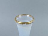 a white vase with a gold rim sitting on a table