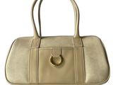 a white purse with a gold ring on the handle