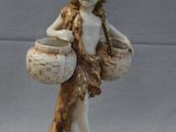 a figurine of a woman with a basket on a rock