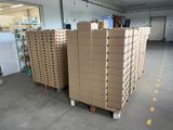 de nombreux cartons empilés sur des palettes dans un entrepôt
