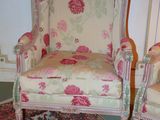 pair of pink and white chairs in a room with a rug on the floor