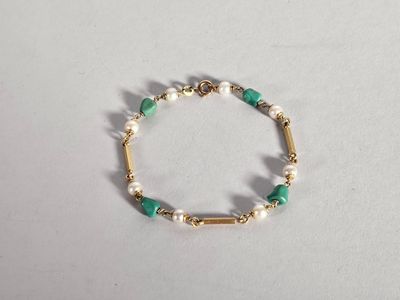 un gros plan sur un bracelet orné de perles et de perles vertes