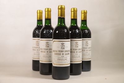 quatre bouteilles de vin sont alignées sur une table