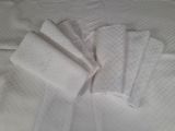 quatre serviettes blanches posées sur un lit blanc