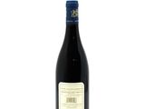 the bottle of wine is sitting on a white surface