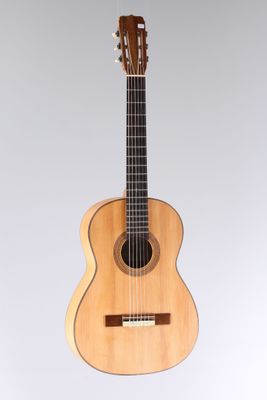 une guitare en bois posée sur une surface blanche