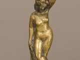 une photo d'une figurine en or représentant une femme, posée sur une table