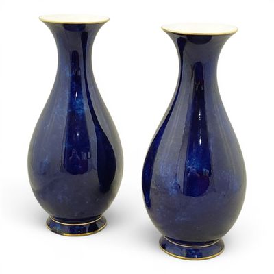 deux vases bleus posés l'un à côté de l'autre sur une surface blanche