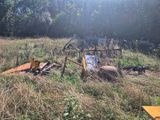 un tracteur immobilisé dans l'herbe, équipé d'une charrue